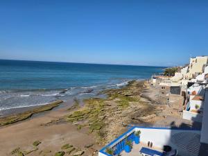 a view of a beach with buildings and the ocean at Terrasse sur l'azur in Taghazout