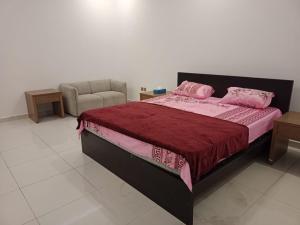 阿吉曼LUXURY Properties的卧室里有一张床,上面有粉色枕头和一把椅子