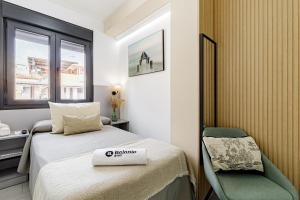 a small room with a bed and a chair at Stay Belonio L'Prados in Málaga