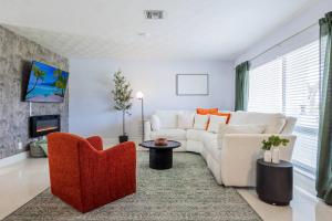 Una sala de estar con un sofá blanco y sillas. en Modern Family Pool Home Near Beach Vibes, en Hollywood