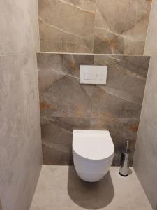 aseo blanco en un baño con pared de piedra en Willa Cynamon Garden, en Busko-Zdrój 18 fotos más