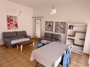 a living room with a couch and a table at Anahi Homes Corralejo -Villa Codeso 7 in La Oliva