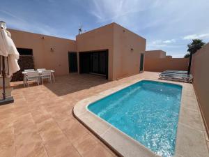 a swimming pool on the patio of a house at Anahi Homes Corralejo -Villa Codeso 7 in La Oliva