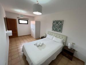 a bedroom with a white bed with two candles on it at Anahi Homes Corralejo -Villa Codeso 7 in La Oliva