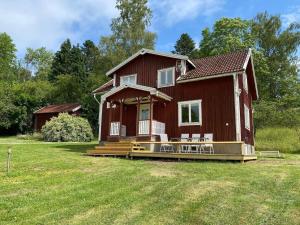 a large red house with a large front porch at 8 person holiday home in ANNEBY-By Traum in Aneby