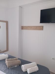 a room with towels and a mirror and a television at Lendas Paradise studio number 1 in Lentas