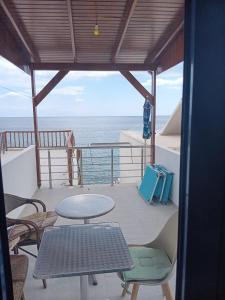 a balcony with a table and chairs and the ocean at Lendas Paradise studio number 1 in Lentas