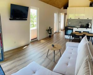 a living room with a white couch and a table at Domek nad Drawskim in Stare Drawsko