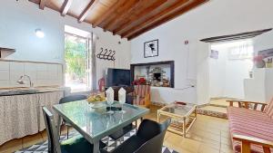Una cocina y una sala de estar con mesa y sillas. en Finca Paraiso Casa Rural Tenerife, en La Laguna