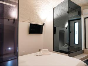 a bathroom with a mirror and a bed and a tv at Lupariello Relais in Altamura