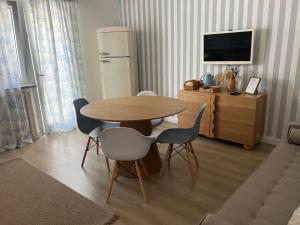 チヴィタノーヴァ・マルケにあるCasa Jouy con giardino a due passi dal mareのダイニングルーム(テーブル、椅子、冷蔵庫付)