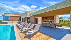 a patio with chairs and a swimming pool at Luxury Villa Vigneto heated pool jacuzzi in Brtonigla