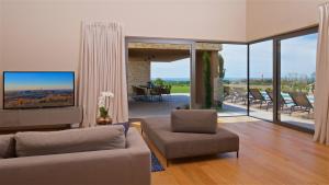 a living room with a couch and a table and chairs at Luxury Villa Vigneto heated pool jacuzzi in Brtonigla