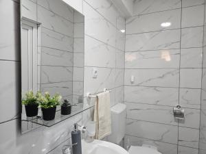 a white bathroom with a sink and a mirror at ,,Villa Vera" Peshtani in Peštani
