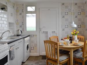 a kitchen with a table and chairs and a sink at Mid Bishopton Cottage - Uk10910 in Whithorn