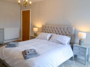 a bedroom with a large white bed with towels on it at Jubilee House in Alnwick