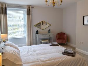 a bedroom with a large white bed and a window at Jubilee House in Alnwick +6 photos
