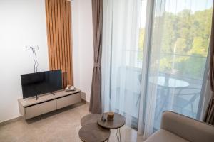a living room with a tv and a large window at Robi Apartments in Ulcinj