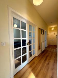 an empty room with large glass doors and wooden floors at Edinburgh Centre - George Square Residence in Edinburgh