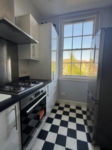 a kitchen with a black and white checkered floor at Edinburgh Centre - George Square Residence in Edinburgh