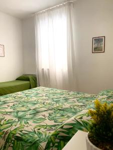 a bedroom with a bed with a green comforter and a window at Villa Marhù in Mattinata +136 photos
