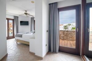a bedroom with a bed and a sliding glass door at Hotel Boutique Zahara in Zahara de los Atunes