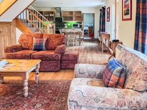 a living room with two couches and a table at The Old Post Office - Cottage in Arnisdale
