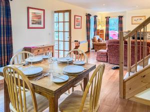 a dining room with a wooden table and chairs at The Old Post Office - Cottage in Arnisdale +12 photos