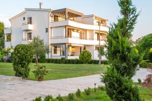 a large white house with a yard at Robi Apartments in Ulcinj