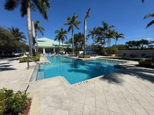 a swimming pool with palm trees in a resort at Exclusive Doral Villa with Luxury Amenities in Miami