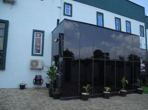 a large glass building with potted plants in front of it at Hotel Vegas in Mama