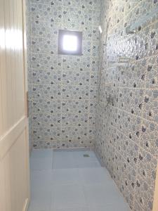 a bathroom with a shower with a small window at kaouki beachside apertmment - 4 peoples in Essaouira +9 photos