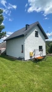 een wit huis met een boot in een tuin bij Domek w Limanowej in Limanowa