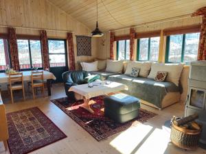 a living room with a couch and a table at Reinunga Eco Hytta - Mountain lodge near Myrdal accessible only by train or bike in Myrdal