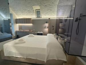 a bedroom with a large white bed with towels on it at Lupariello Relais in Altamura