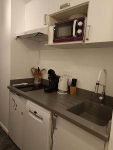 a kitchen with a sink and a microwave at Appartement ARCACHON in Arcachon