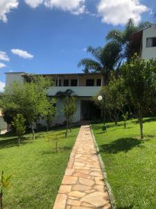 a walkway in front of a building with trees at Hotel Fazenda Tucano in Capim Branco