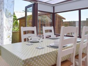 einen Tisch mit weißen Stühlen und einen Tisch mit Brille in der Unterkunft Pembroke Cottage in Pembroke