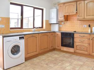 eine Küche mit Waschmaschine und Geschirrspüler in der Unterkunft Pembroke Cottage in Pembroke