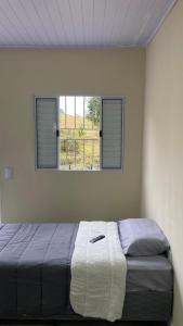 a bedroom with a bed with towels on it at Pousada San Matheus in São Miguel Arcanjo