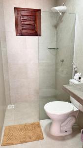 a bathroom with a toilet and a glass shower at Lounge Pdd - Espaço inteiro in Aquiraz +16 photos