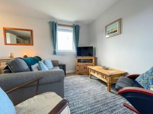 a living room with a couch and a table at The Old Surgery in Kinlochbervie