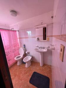 a pink bathroom with two toilets and a sink at Alpinas San Lorenzo in Merlo +31 photos