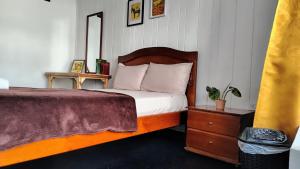 a bedroom with a bed and a dresser and a mirror at Casa Atajo hostal in Armenia