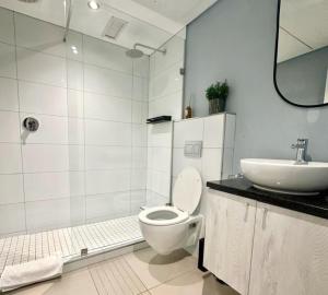 a white bathroom with a toilet and a sink at Chic Apartment in De Waterkant in Cape Town +12 photos