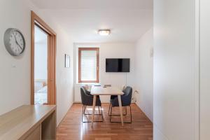 Pokój ze stołem, krzesłami i zegarem w obiekcie Apartmán Hotel Vomočil Bystré w mieście Bystré