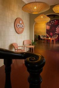 a waiting room with chairs and tables and a sign at awā San José in San José