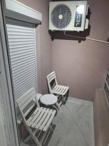 a room with two chairs and a table and a fan at Apartman Centar Visegrad in Višegrad