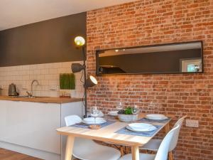 a dining room with a table and a brick wall at River Lodge Annexe in Rhondda