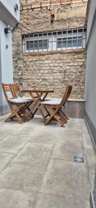 Apartments by Ernes City Hall Sarajevo في سراييفو: كرسيان خشبيان يجلسون بجوار مبنى من الطوب +40 صورة